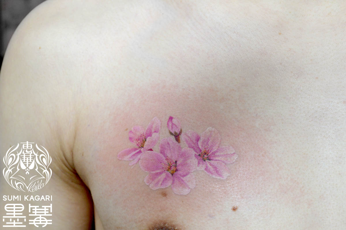 胸に施した淡い桜のタトゥー 。 東京都港区の女性彫師 恵華・プライベートタトゥースタジオ墨篝によるオーダーメイドの花タトゥー・刺青作品です。